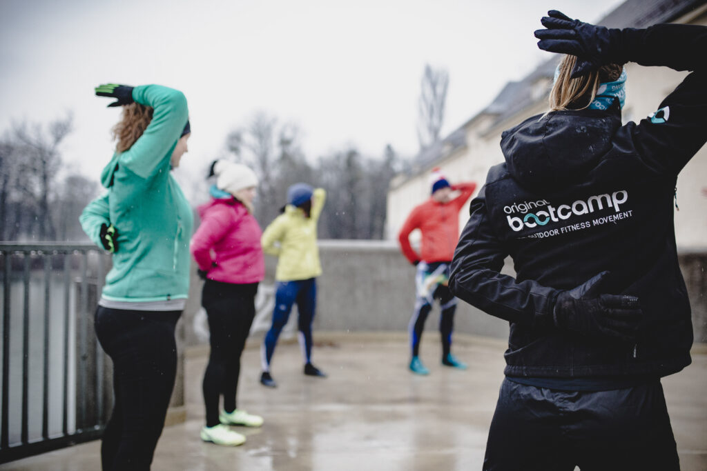 Personal Trainer Alternativen Outdoor Bootcamp Gruppe trainiert gemeinsam bei kaltem Wetter mit Coach im Freien