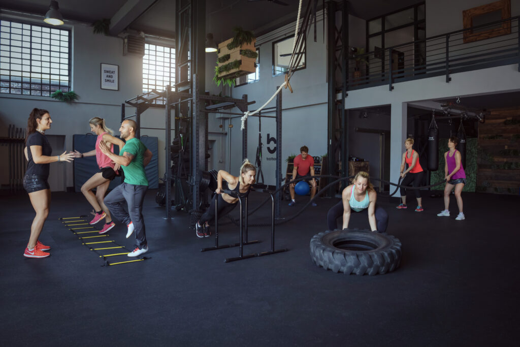 Personal Trainer Alternativen funktionelles Gruppentraining im Fitnessstudio mit verschiedenen Übungen und Geräten