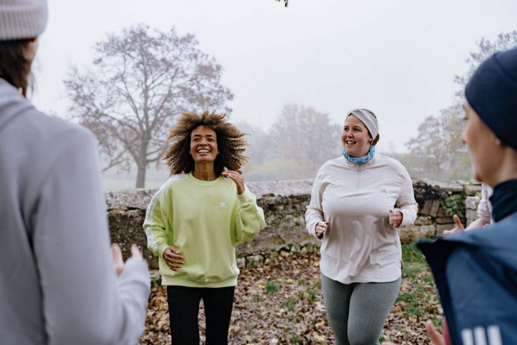 Pace und Herzfrequenz beim Laufen – Läufergruppe mit unterschiedlichen Tempi joggt gemeinsam auf Feldweg, inklusives Training