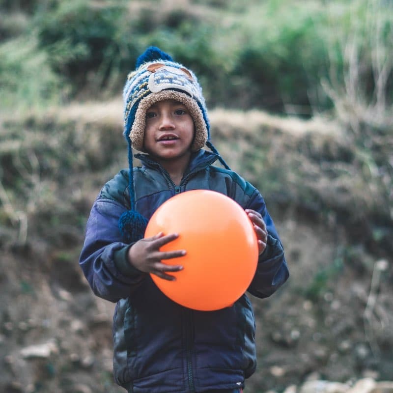 Kind aus Nepal spielt mit einem Ballon