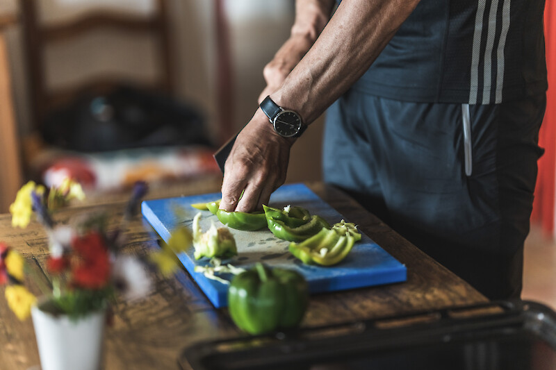 Frische Paprika schneiden als Teil einer ausgewogenen Ernährung zum Abnehmen in Kombination mit Zirkeltraining