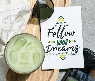 Iced Matcha Latte auf einem Holztisch dekoriert mit Erdbeeren