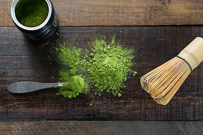 Matcha Pulver in Schale mit traditionellem Bambusbesen