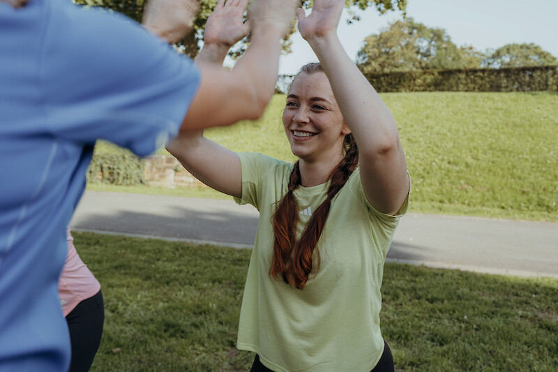 Neujahr Fitness: Motivierende High-Five-Szene im Gruppentraining, Gemeinschaft und Spaß als Schlüssel für langfristige Fitnessvorsätze.
