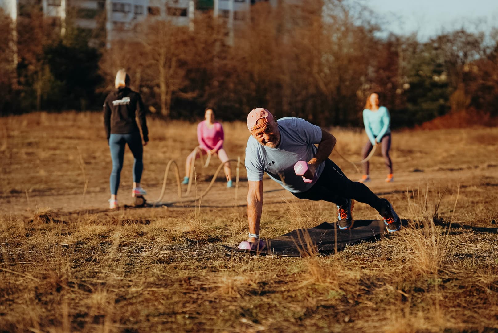 Mann mach eine Plank mit Gewichten in der Hand im freuen auf einer Matte